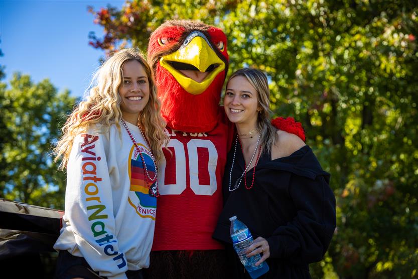 Two girls take a photo with the RHS mascot